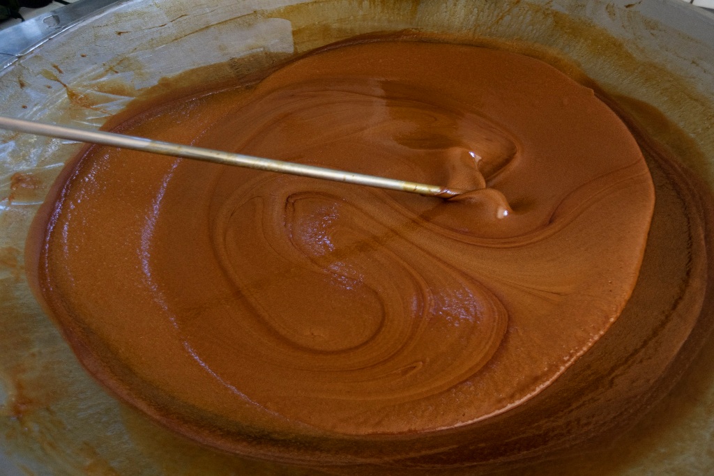 Doceira misturando calda de cana em tacho em Baixo Guandu - Imagem NITRO Historias Visuais