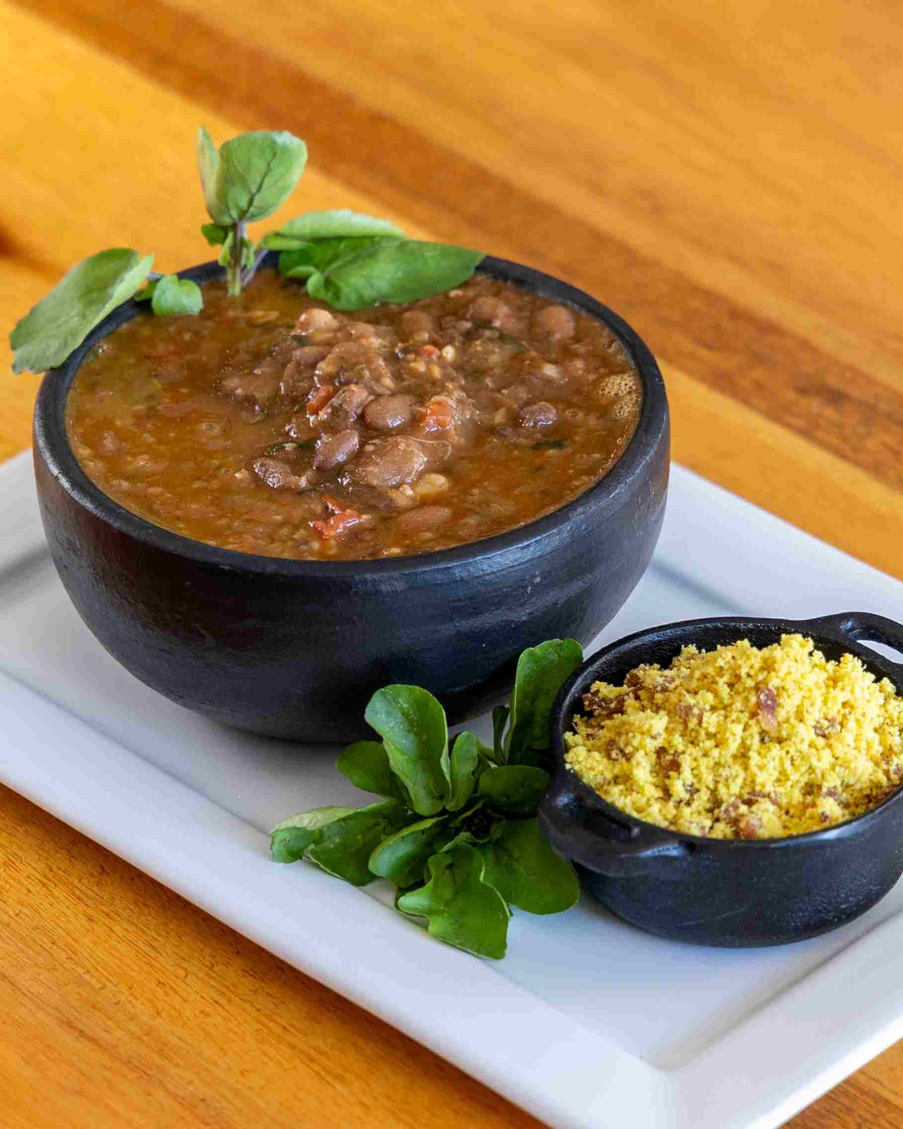 Saquetto Gastrobar – Rabada cozida na pressão com feijão manteiga, servida com agrião e farofa de soja. - Foto: Olho Gordo